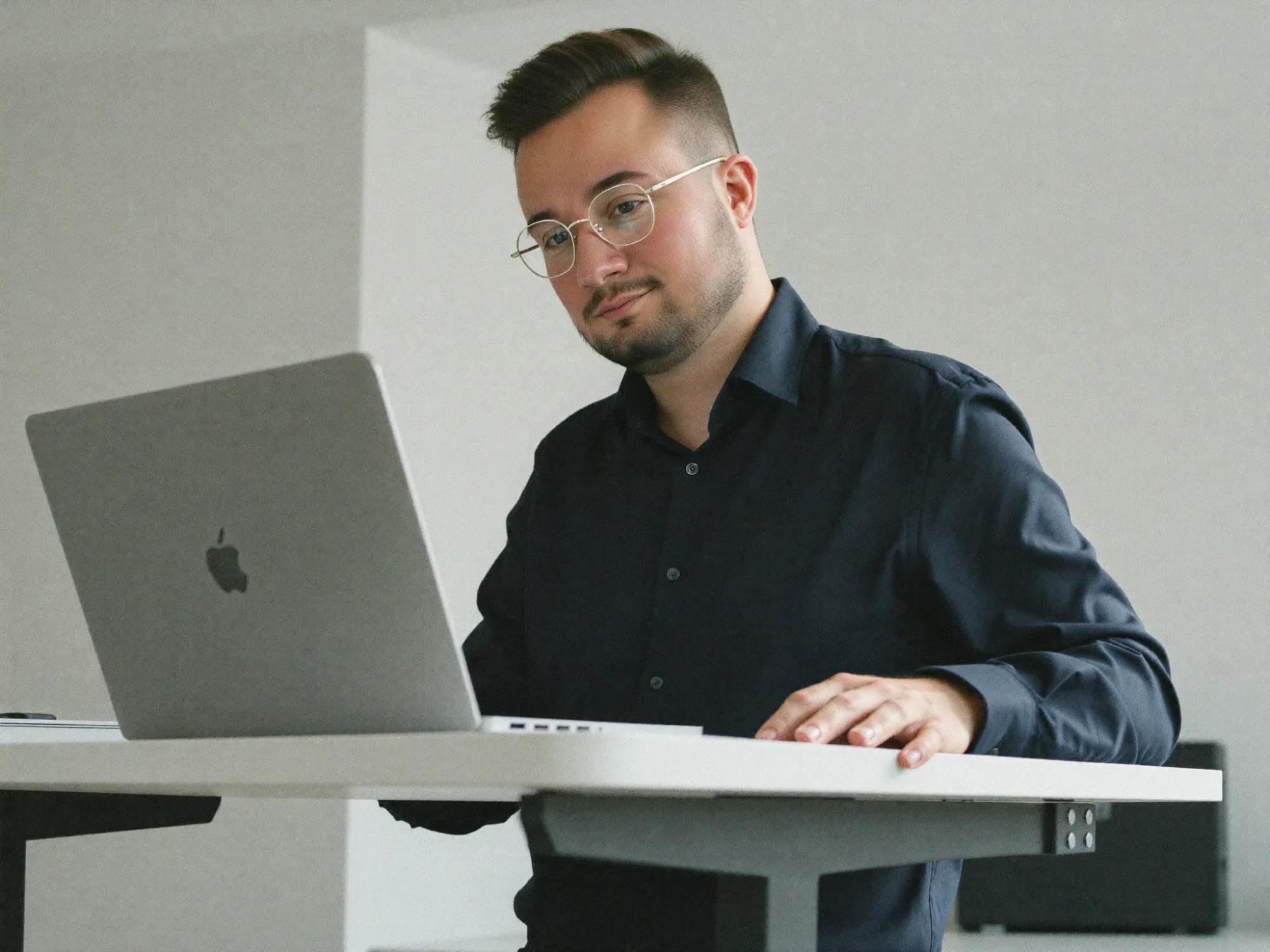 Dominik De Marco arbeitet im Stehen am höhenverstellbaren Pult
