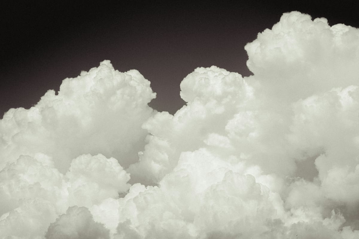 Dichte weiße Wolkenberge vor dunklem Himmel