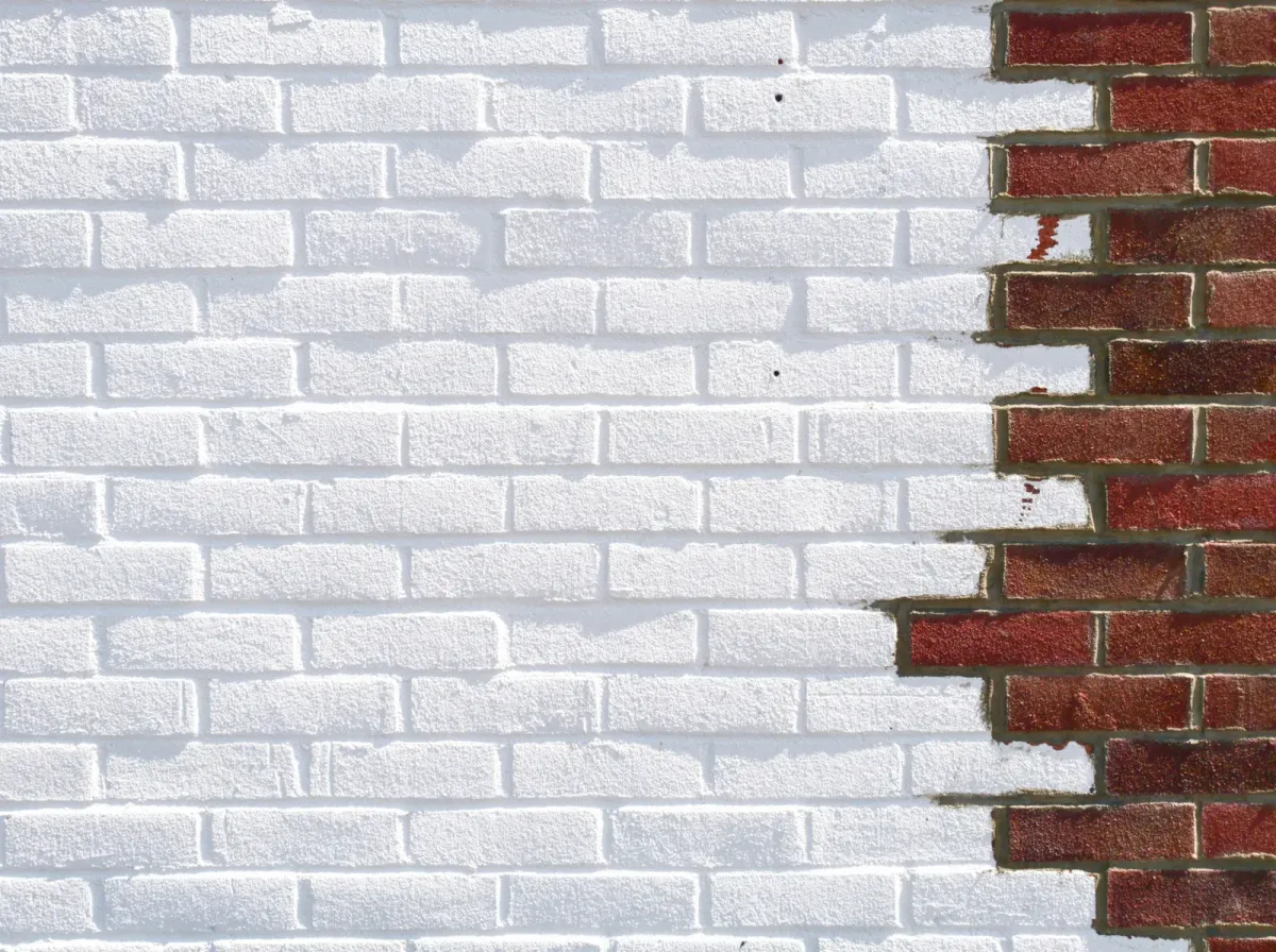 Ziegelwand, links weiß gestrichen, rechts liegen die roten Ziegel frei