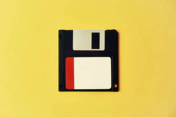 Schwarze 3,5-Zoll-Diskette mit rot-weißem Etikett auf gelbem Hintergrund