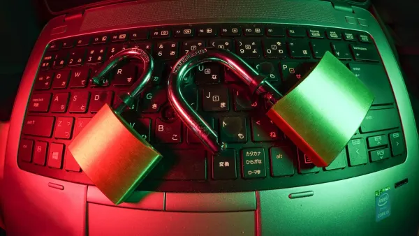 Zwei geöffnete Vorhängeschlösser liegen auf einer Laptop-Tastatur, rot und grün ausgeleuchtet