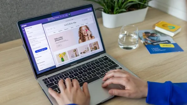 Hände am MacBook, auf dem Bildschirm der Baukasten-Editor eines Onlineshops mit Startseiten-Vorschau